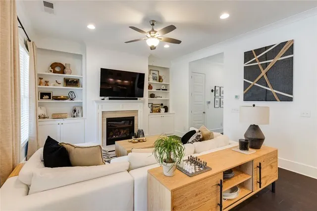 a living room with furniture a flat screen tv and a fireplace