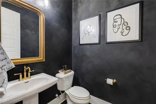 a bathroom with a toilet sink vanity and mirror