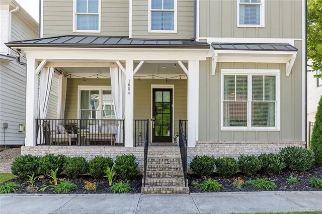 a front view of a house with a lots of windows and plants