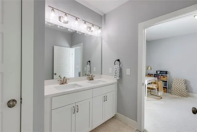 a bathroom with a double vanity sink mirror and next to a window