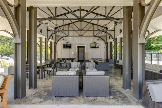 a view of a patio with a dining table and chairs under an umbrella with potted plants