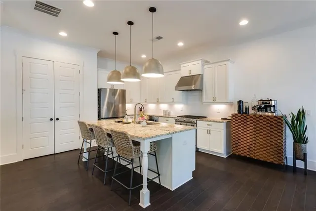 a kitchen with a table chairs stove and wooden floor