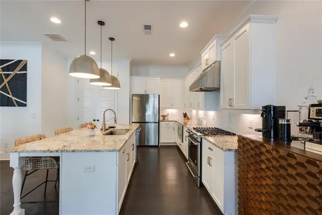 a kitchen with a sink stove and wooden floor