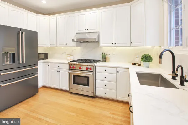 a kitchen with granite countertop a sink stainless steel appliances and cabinets