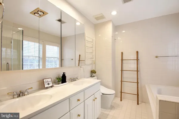 a bathroom with a double vanity sink toilet mirror and shower