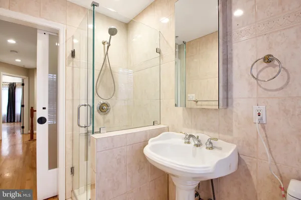 a bathroom with a sink a mirror a glass door a shower and a mirror