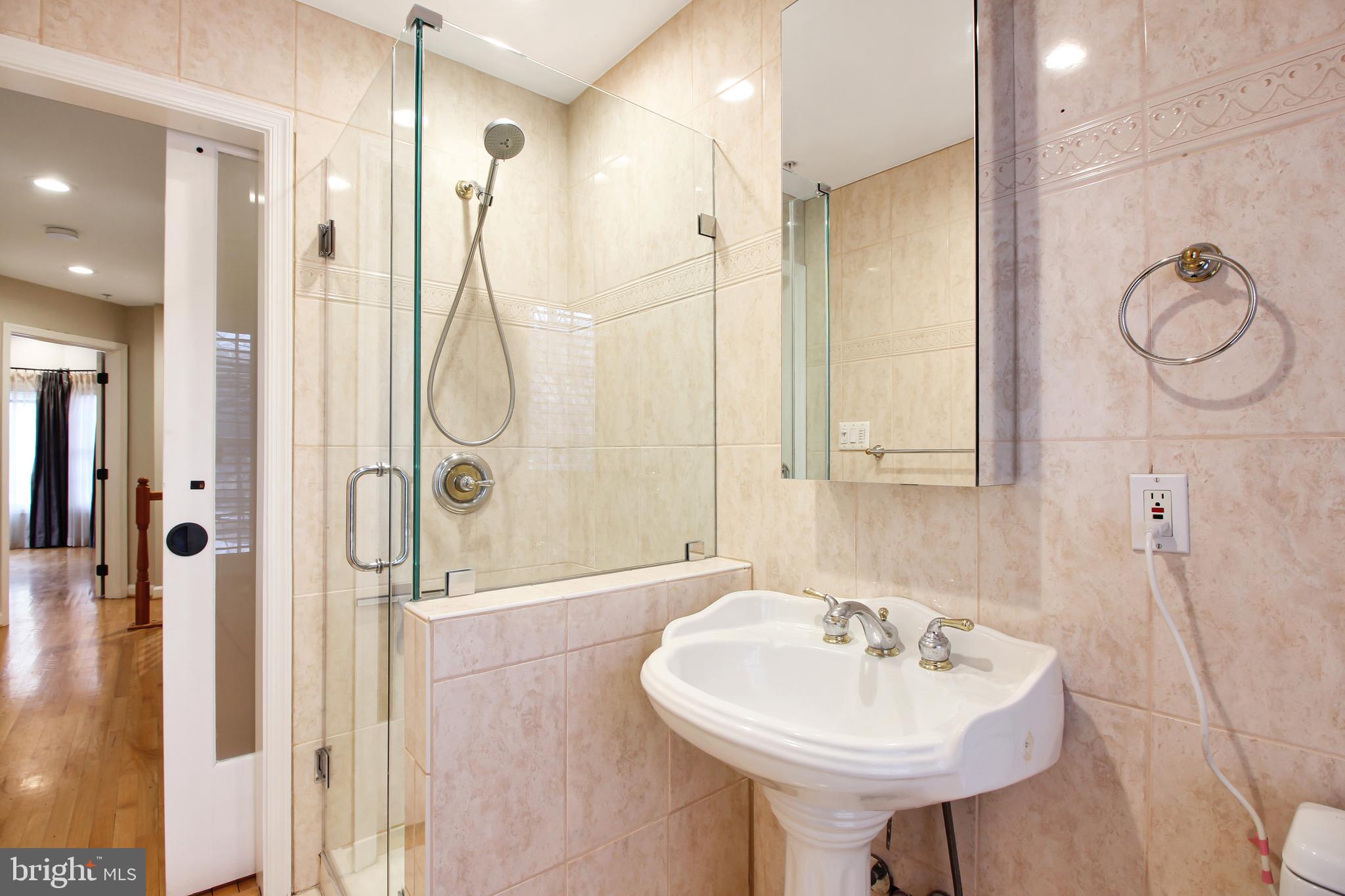 1227 Fidler Lane Silver Spring, MD 20910 - Photo 27 of 33 a bathroom with a sink a mirror a glass door a shower and a mirror