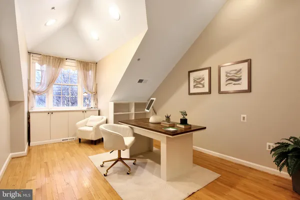 a view of a workspace with furniture and a window