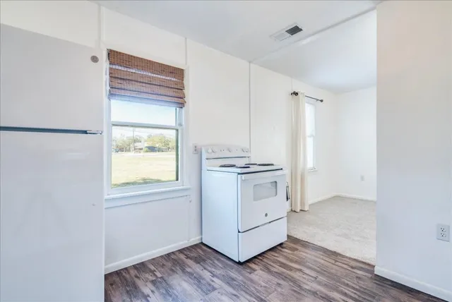 a view of kitchen with wooden floor and electronic appliances