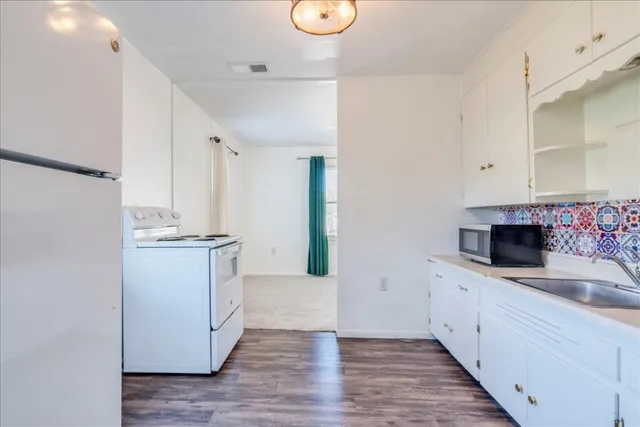 a kitchen with a sink cabinets and wooden floor