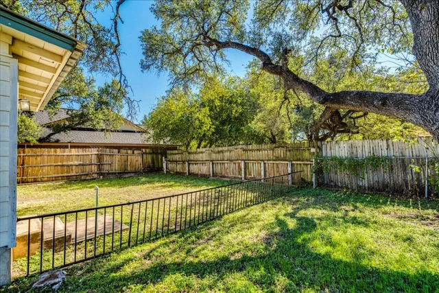 a view of a backyard with wooden fence