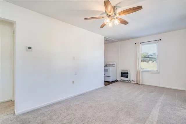 an empty room with chandelier fan