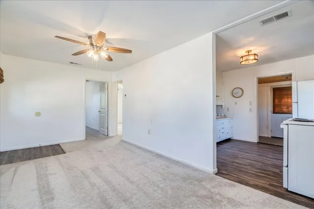 a view of an empty room with closet and a chandelier fan