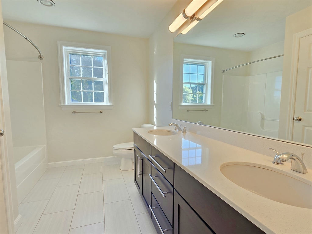 3 Willow Road Ashland, MA 01721 - Photo 39 of 41 a bathroom with a double vanity sink a mirror and a bathtub