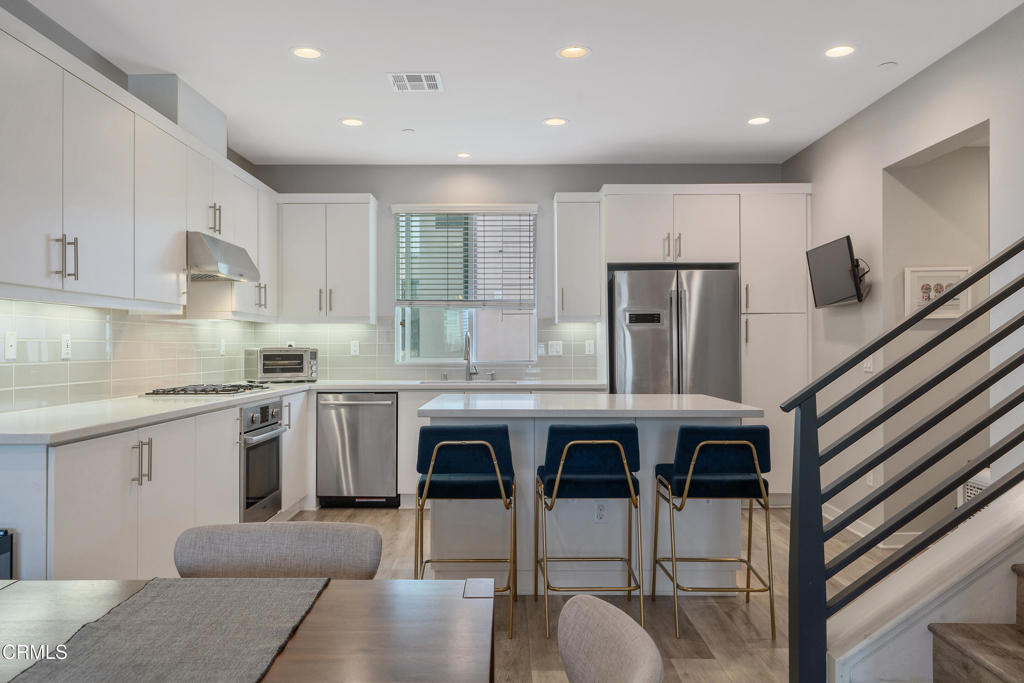 1553 Verbena Way Los Angeles, CA 90041 - Photo 10 of 31 a kitchen with stainless steel appliances granite countertop a kitchen island hardwood floor sink stove and white cabinets