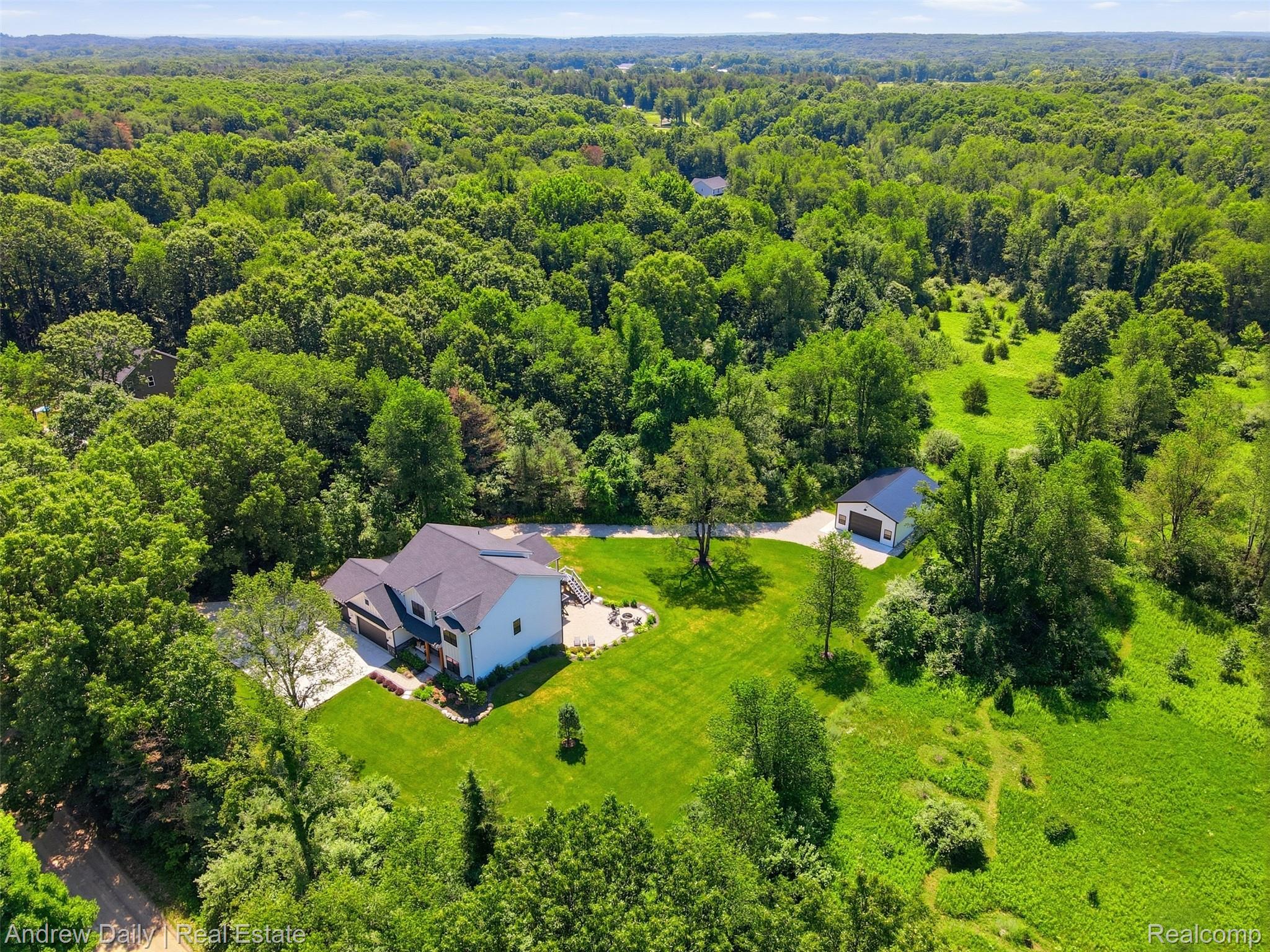 4661 Spears Road Pinckney, MI 48169 - Photo 5 of 56 Expansive property featuring a white residence with a dark roof and an additional detached garage with a dark roof