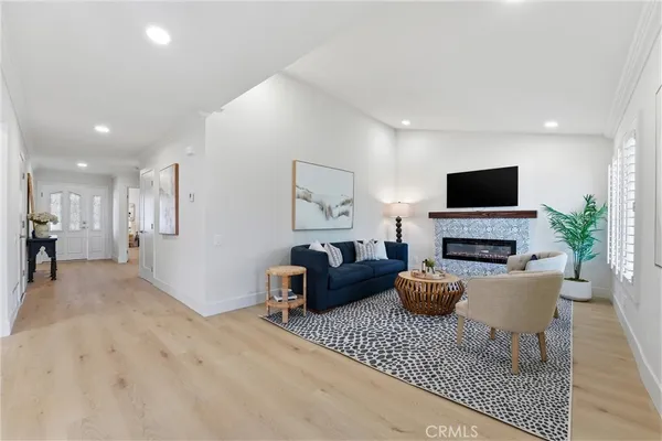 a living room with furniture a flat screen tv and a fireplace