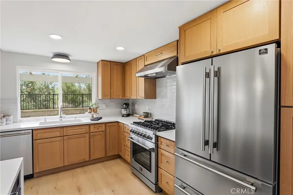 a kitchen with stainless steel appliances a refrigerator sink and cabinets