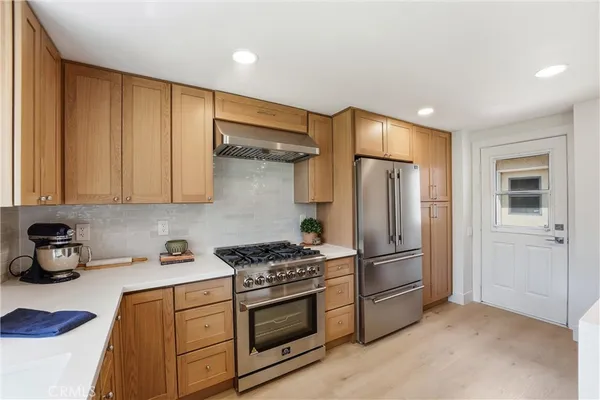 a kitchen with stainless steel appliances granite countertop a refrigerator and a stove top oven