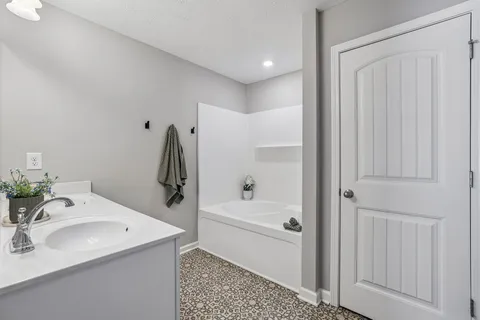 a bathroom with a tub sink and mirror