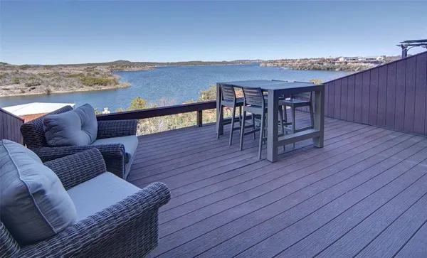 a roof deck with couches and wooden floor