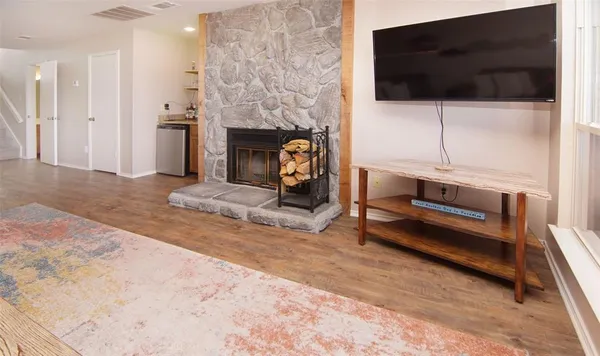 a living room with furniture a flat screen tv and a fireplace