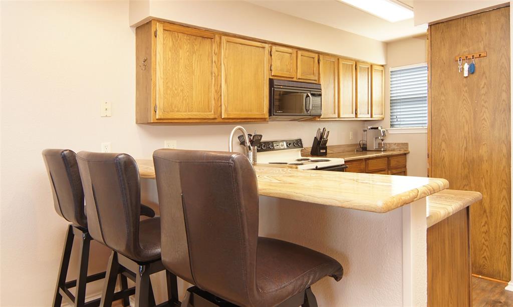 3109 Hells Gate Loop, Unit 59 Strawn, TX 76475 - Photo 5 of 25 a kitchen with a table chairs sink and cabinets