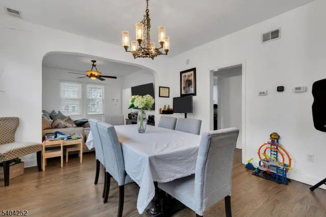 a kitchen with granite countertop a stove a sink dishwasher a dining table and chair with wooden floor