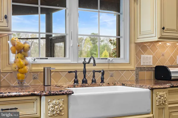 a bathroom with a granite countertop sink a large mirror and a window