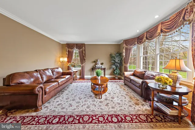 a kitchen with stainless steel appliances kitchen island granite countertop a stove a sink dishwasher and white cabinets with wooden floor