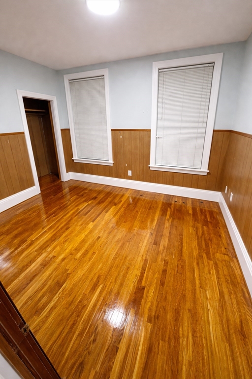 140 Butler Street, Unit 1 Revere, MA 02151 - Photo 2 of 5 a view of an empty room with wooden floor and a window
