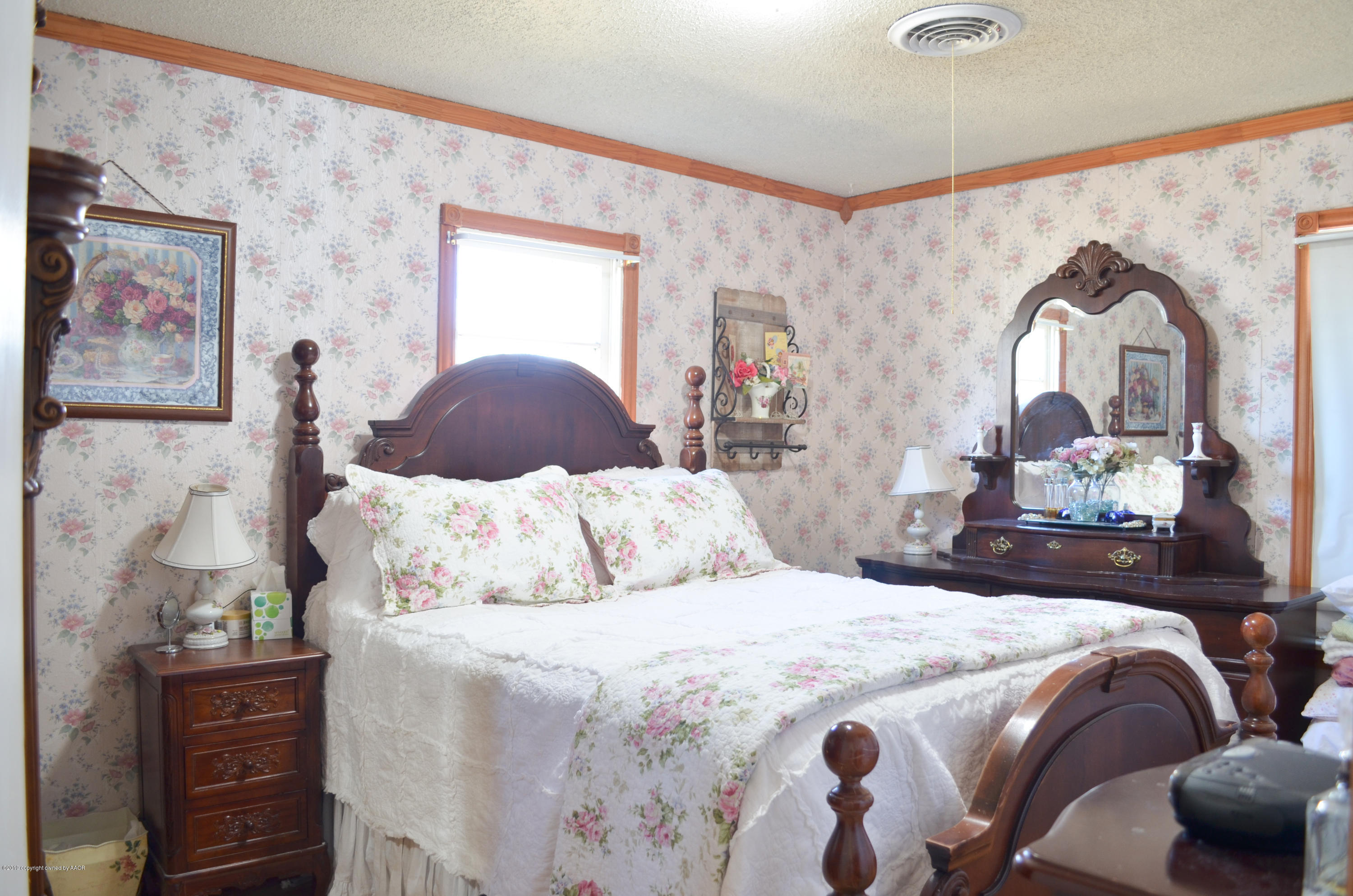 501 Southwest 45th Avenue Amarillo, TX 79110 - Photo 6 of 14 a bedroom with a bed and wooden floor