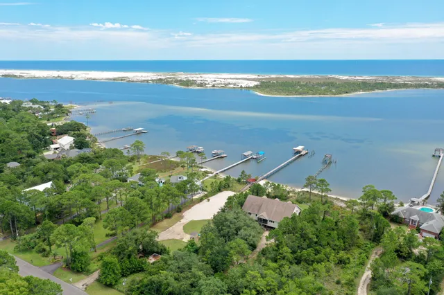 an aerial view of ocean and residential houses with outdoor space