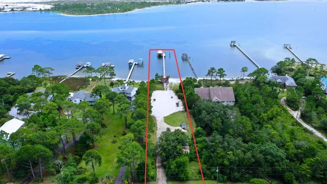 an aerial view of a house with a yard and lake view