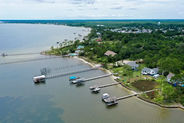 an aerial view of a house with a yard and lake view