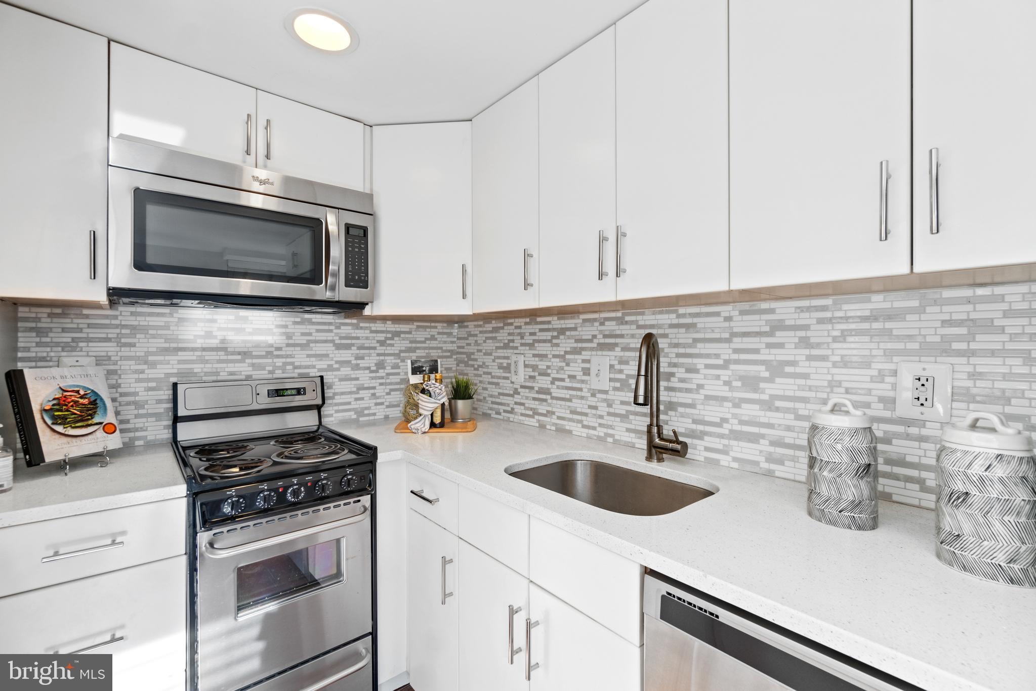 1701 16th Street Northwest, Unit 421 Washington, DC 20009 - Photo 11 of 20 a kitchen with stainless steel appliances a sink stove and microwave