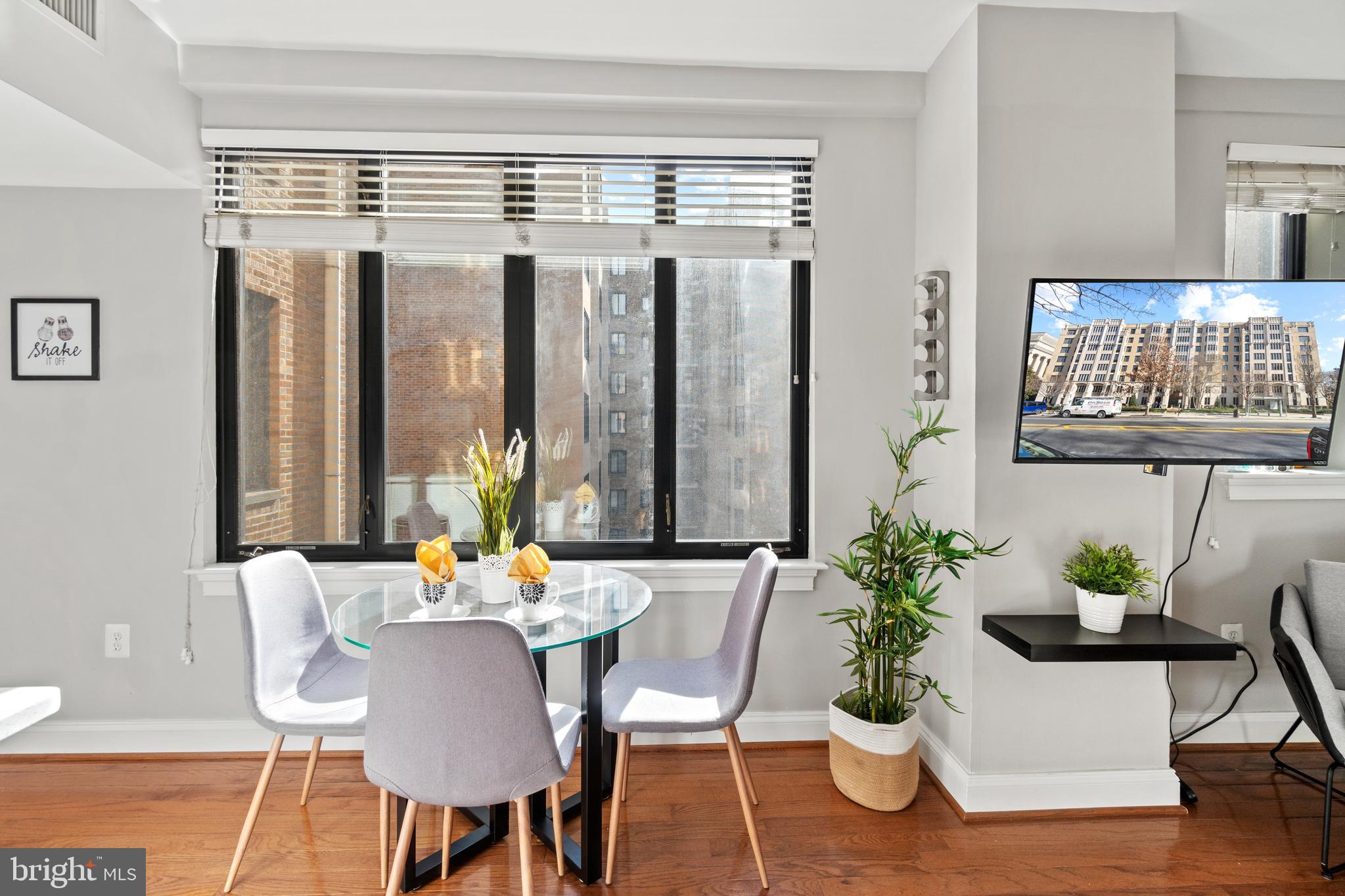 1701 16th Street Northwest, Unit 421 Washington, DC 20009 - Photo 4 of 20 a dining room with furniture potted plants and wooden floor