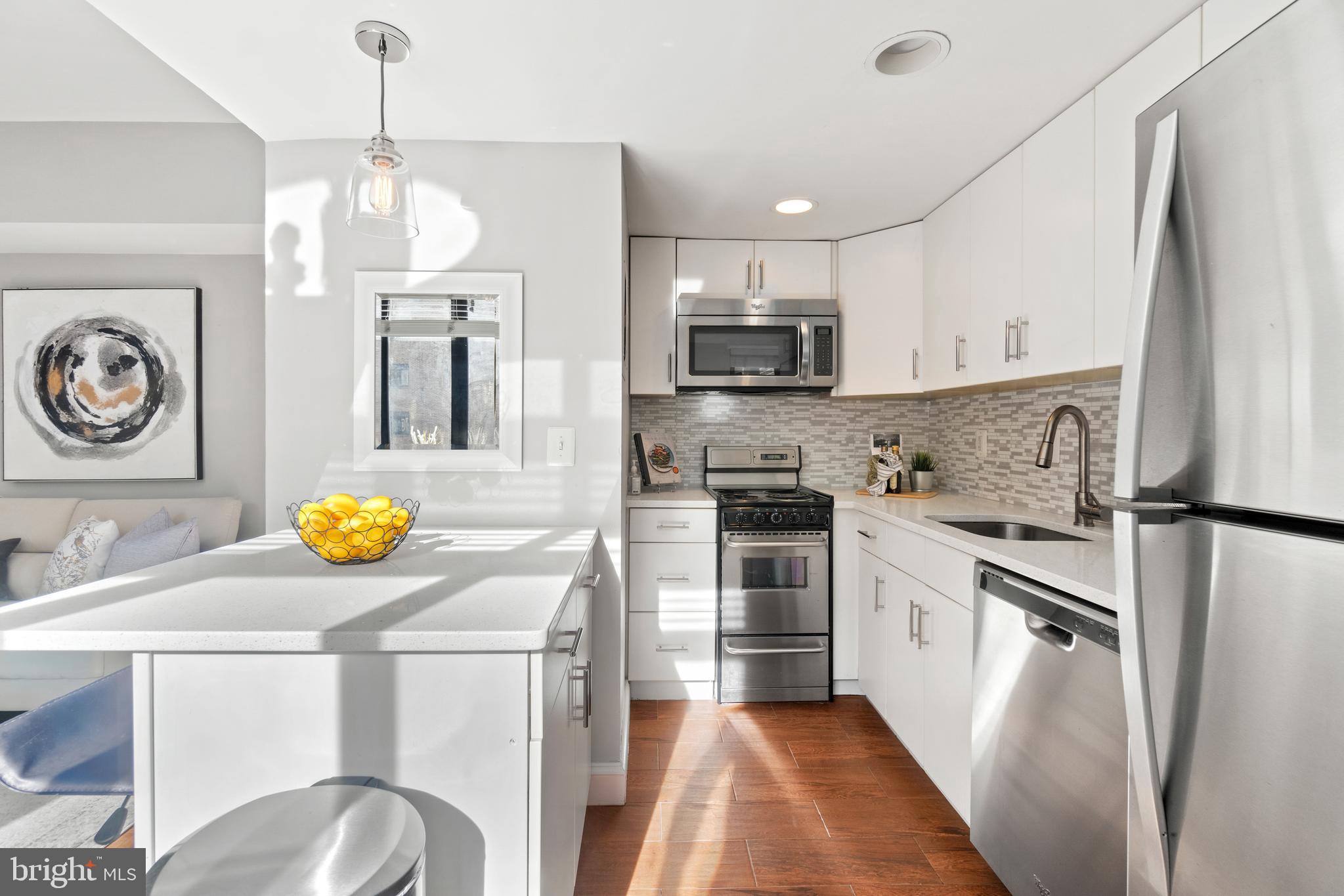 1701 16th Street Northwest, Unit 421 Washington, DC 20009 - Photo 9 of 20 a kitchen with stainless steel appliances a stove a sink refrigerator and a stove