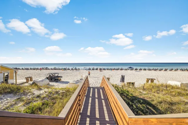 an aerial view of ocean and residential houses with outdoor space and swimming pool