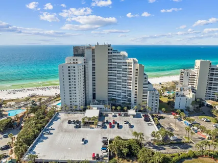 an aerial view of a city with lots of residential buildings ocean and mountain view in back