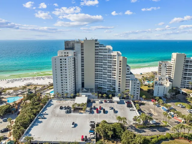 an aerial view of a city with lots of residential buildings ocean and mountain view in back
