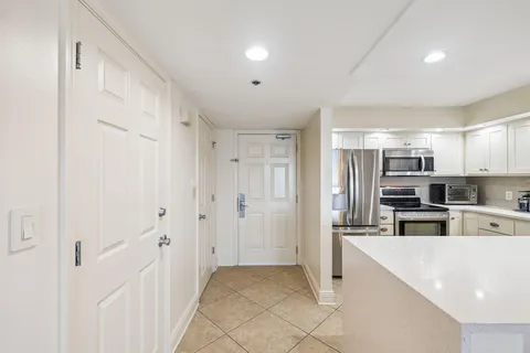 a kitchen with white cabinets stainless steel appliances and sink