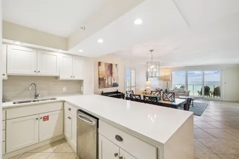 a kitchen with kitchen island a stove a table and chairs