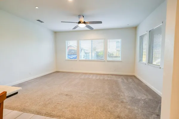 en empty room with window and ceiling fan