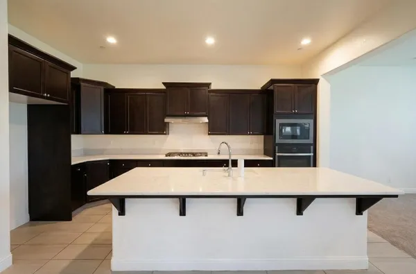 a kitchen with stainless steel appliances a refrigerator and a stove top oven