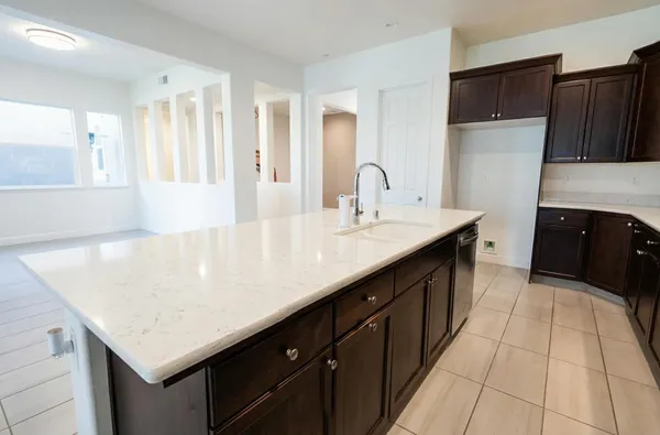 a large kitchen with stainless steel appliances a large counter top and a stove