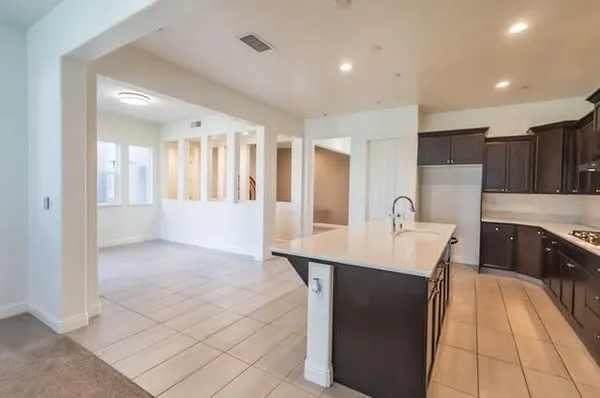 a view of an empty room with window and hardwood floor
