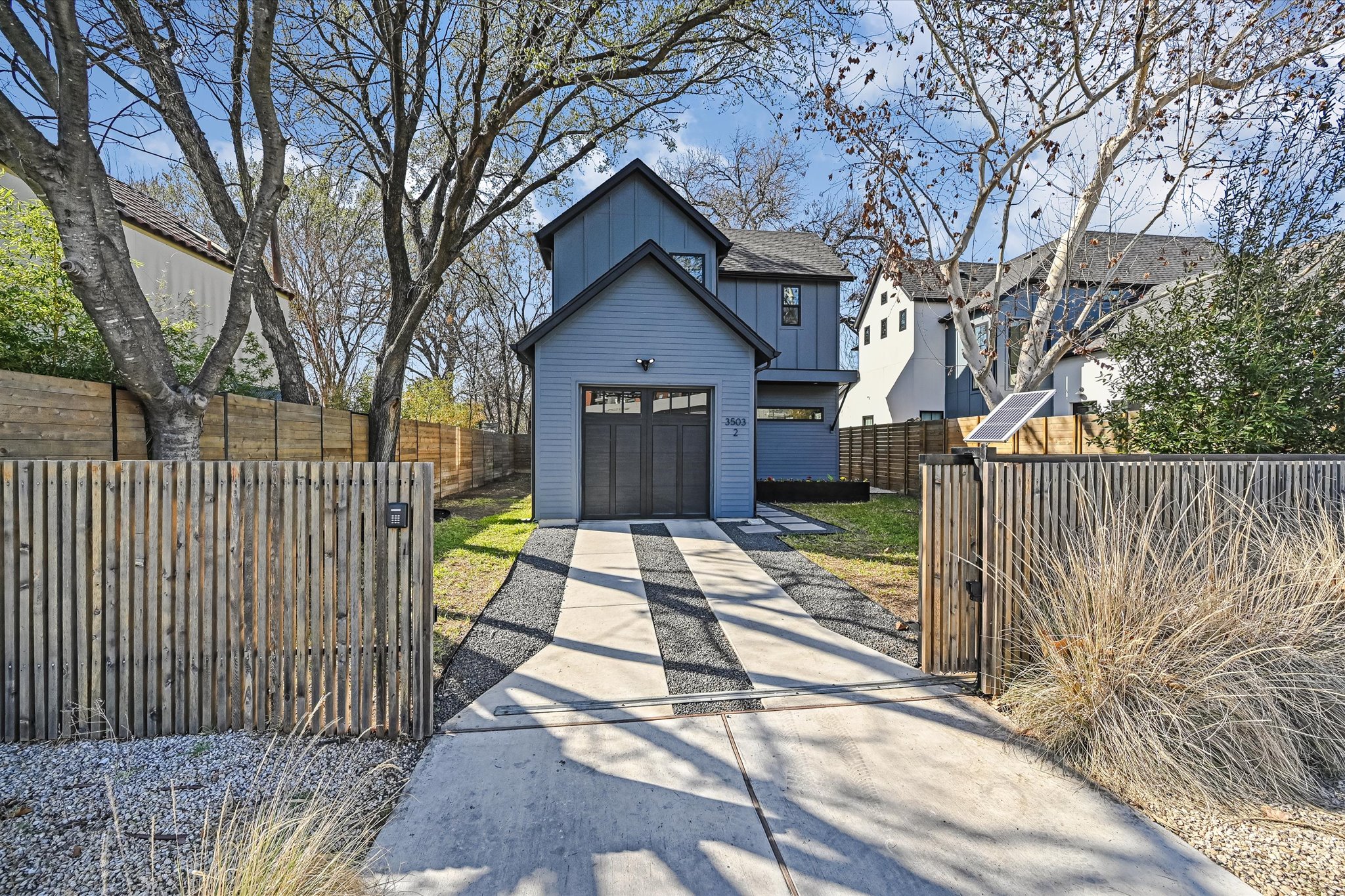 a view of a brick house with a large trees next to a yard