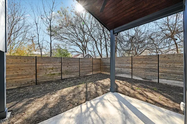 a view of a yard with wooden fence