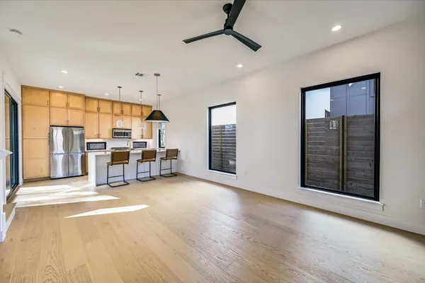 a view of a big room with wooden floor windows and cabinet